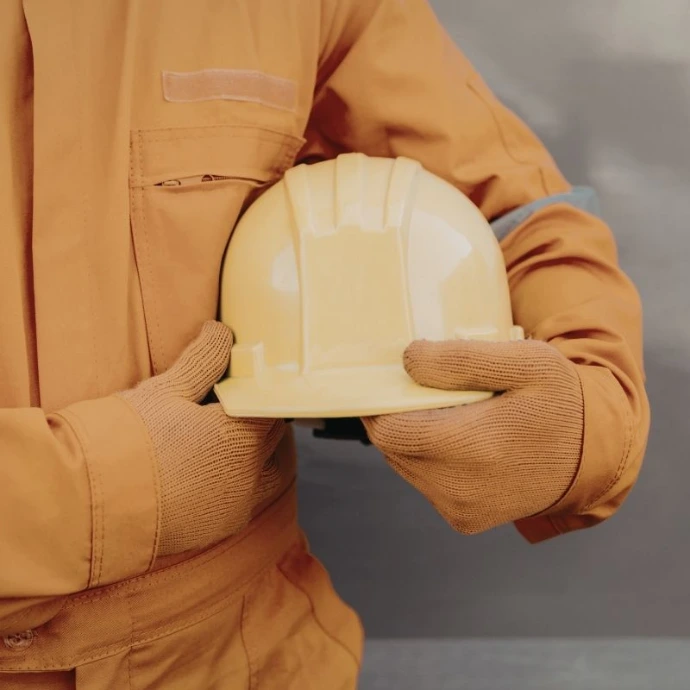 Engineer holding helmet